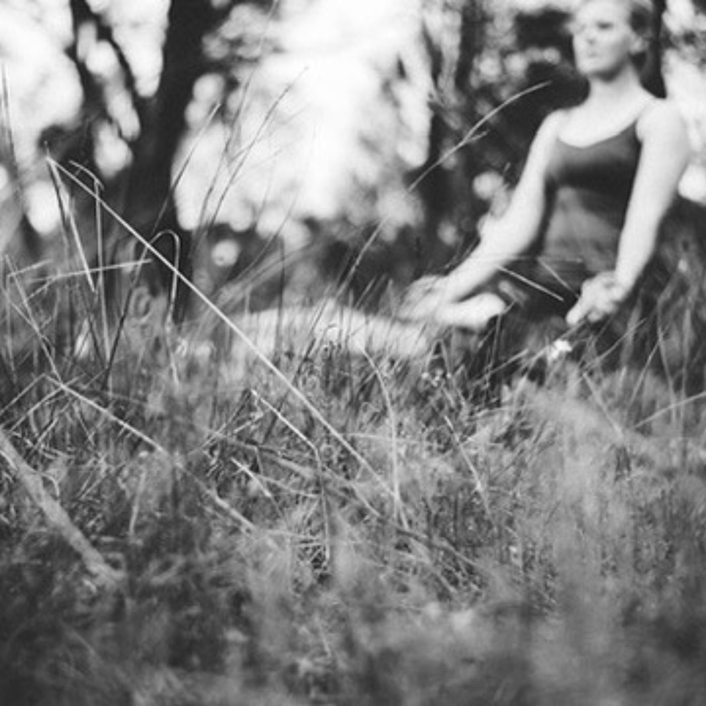 Fionna in long grass beneath trees, softly out of focus